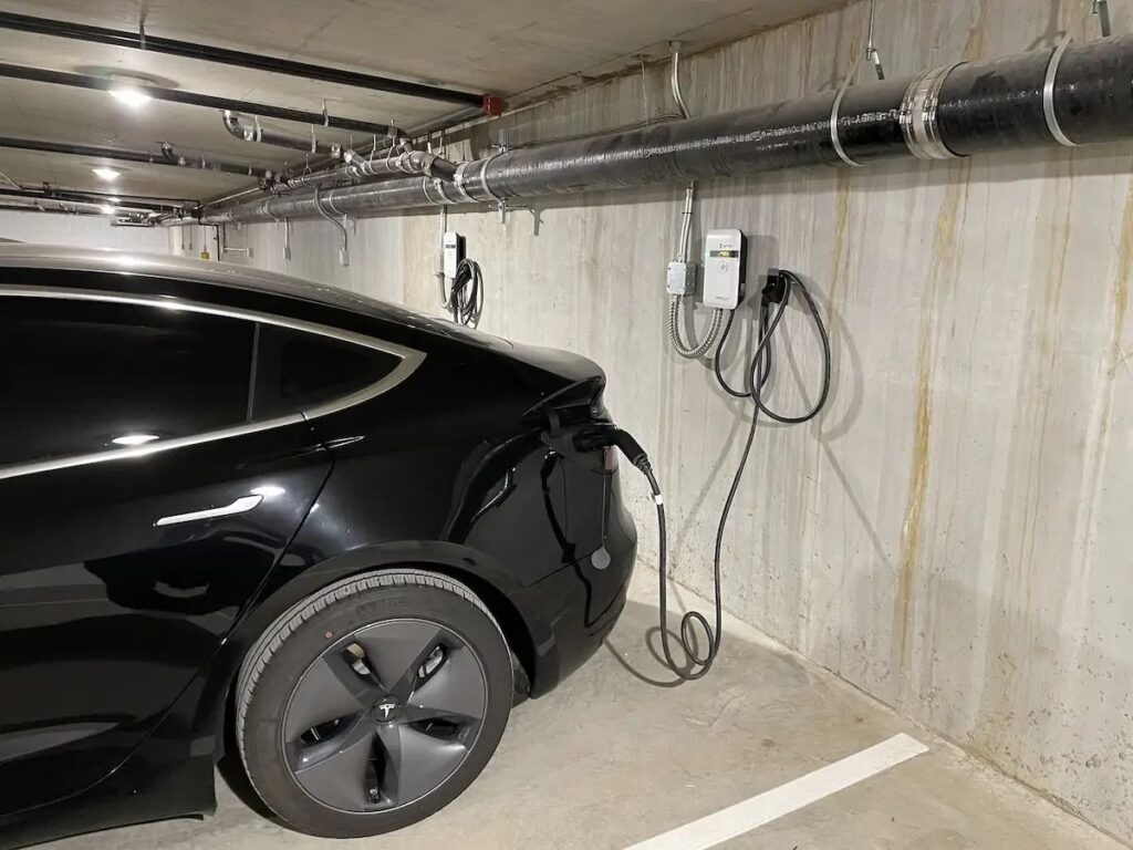 Electric vehicle plugged into condo parking EV charging station