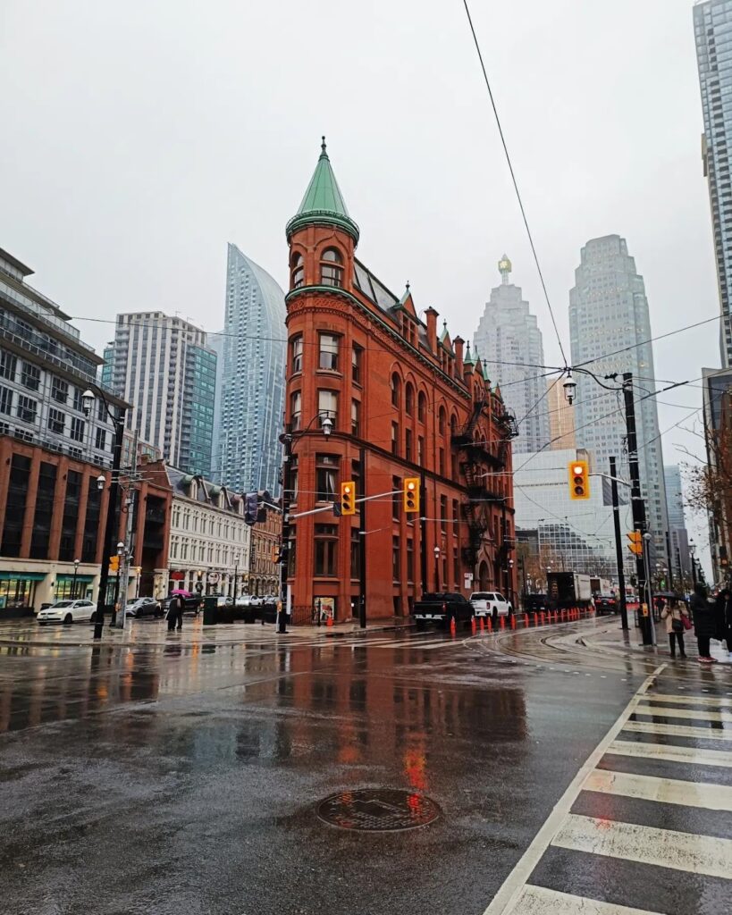 Toronto Flatiron Building on rainy day with city reflections